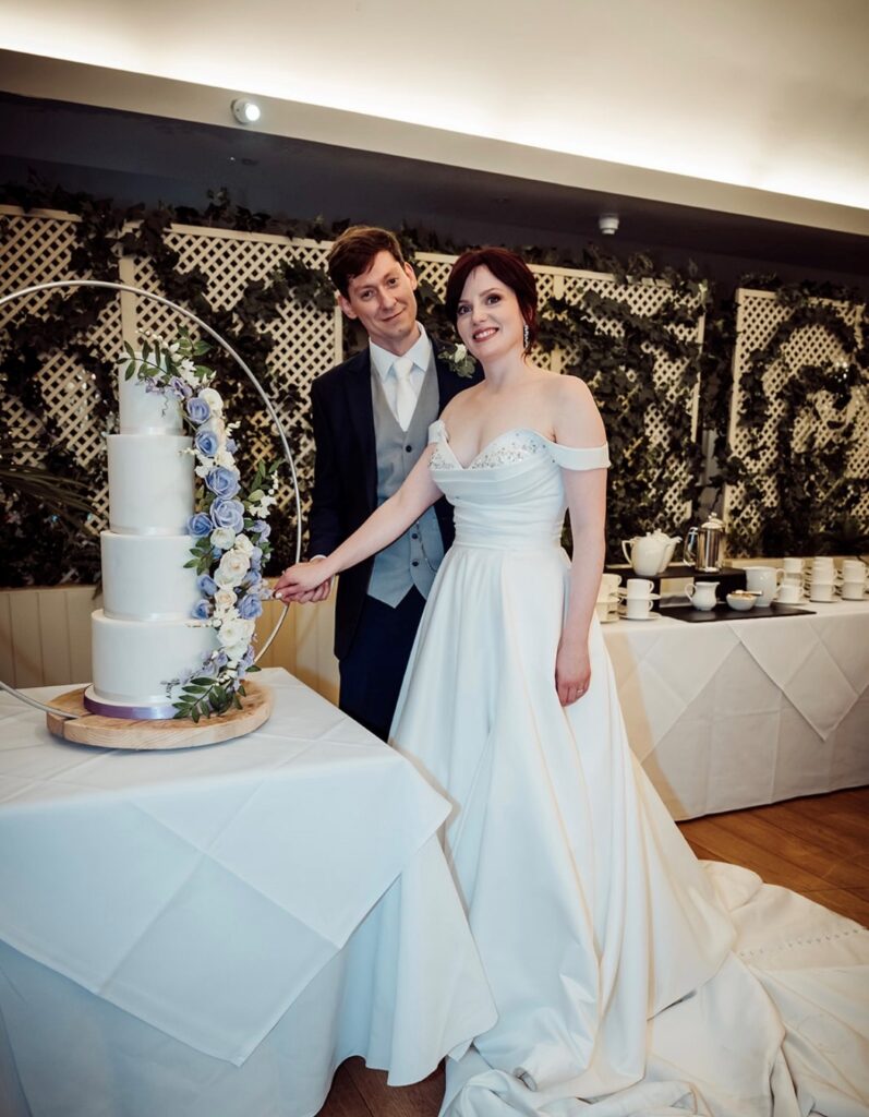 Four tier ivory cake with lilac and ivory roses, lisianthus, sweet peas, peonies and ruscus